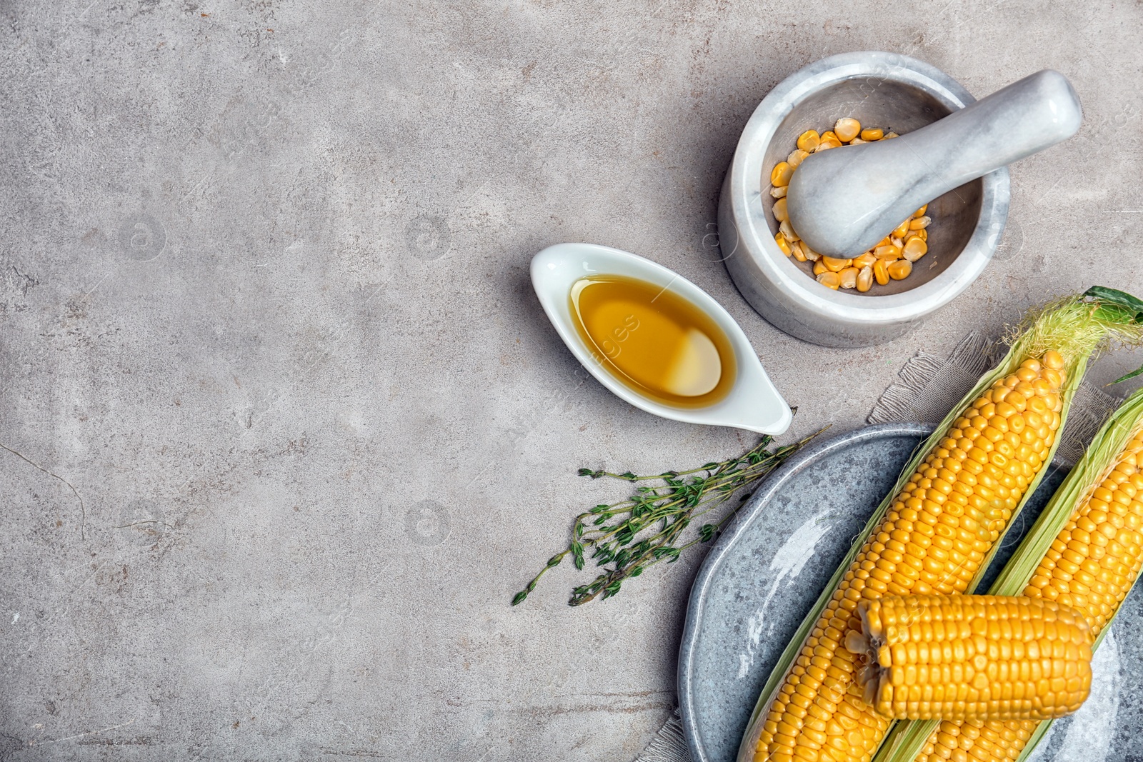 Photo of Flat lay composition with gravy boat of corn oil, cobs and kernels on light background