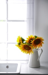 Bouquet of beautiful sunflowers on counter in kitchen