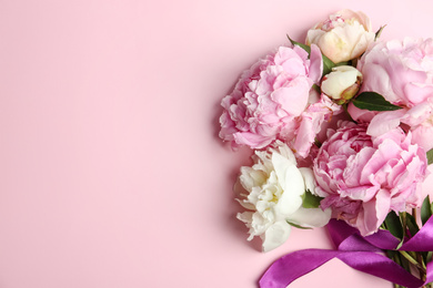Photo of Bouquet of beautiful peonies with ribbon on pink background, flat lay. Space for text