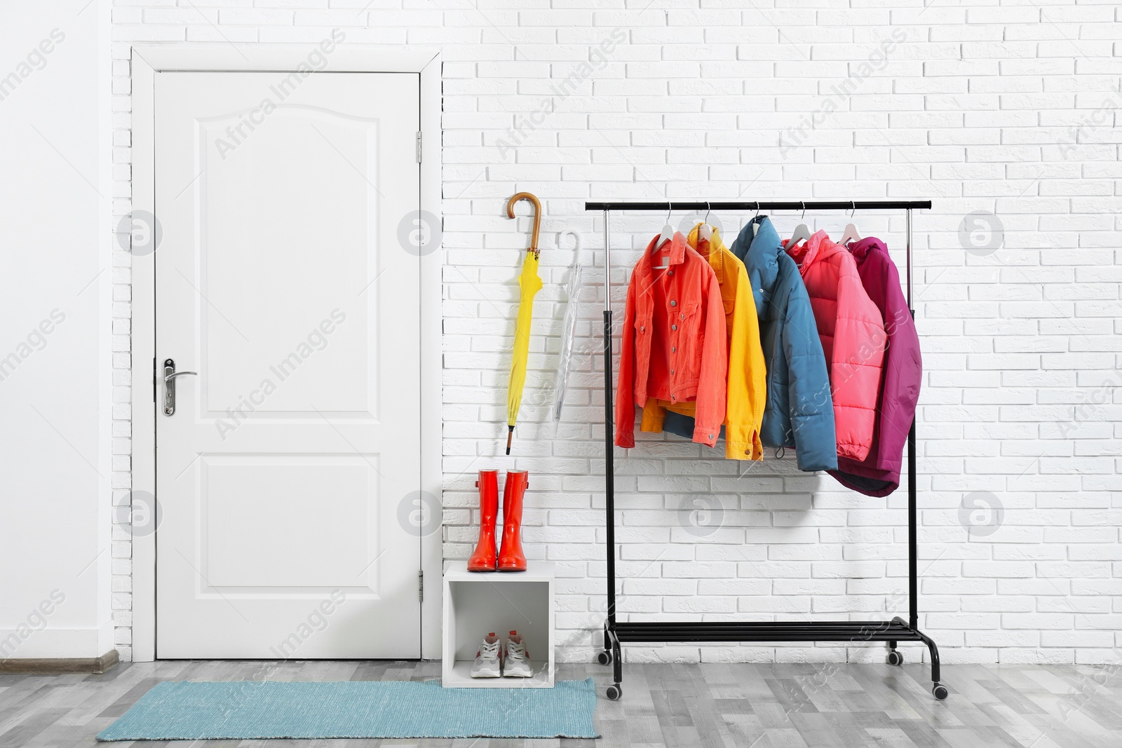 Photo of Rack with stylish warm jackets in hallway