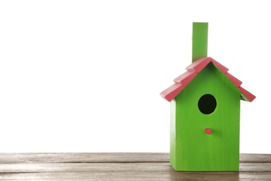 Photo of Beautiful green bird house on wooden table against white background, space for text