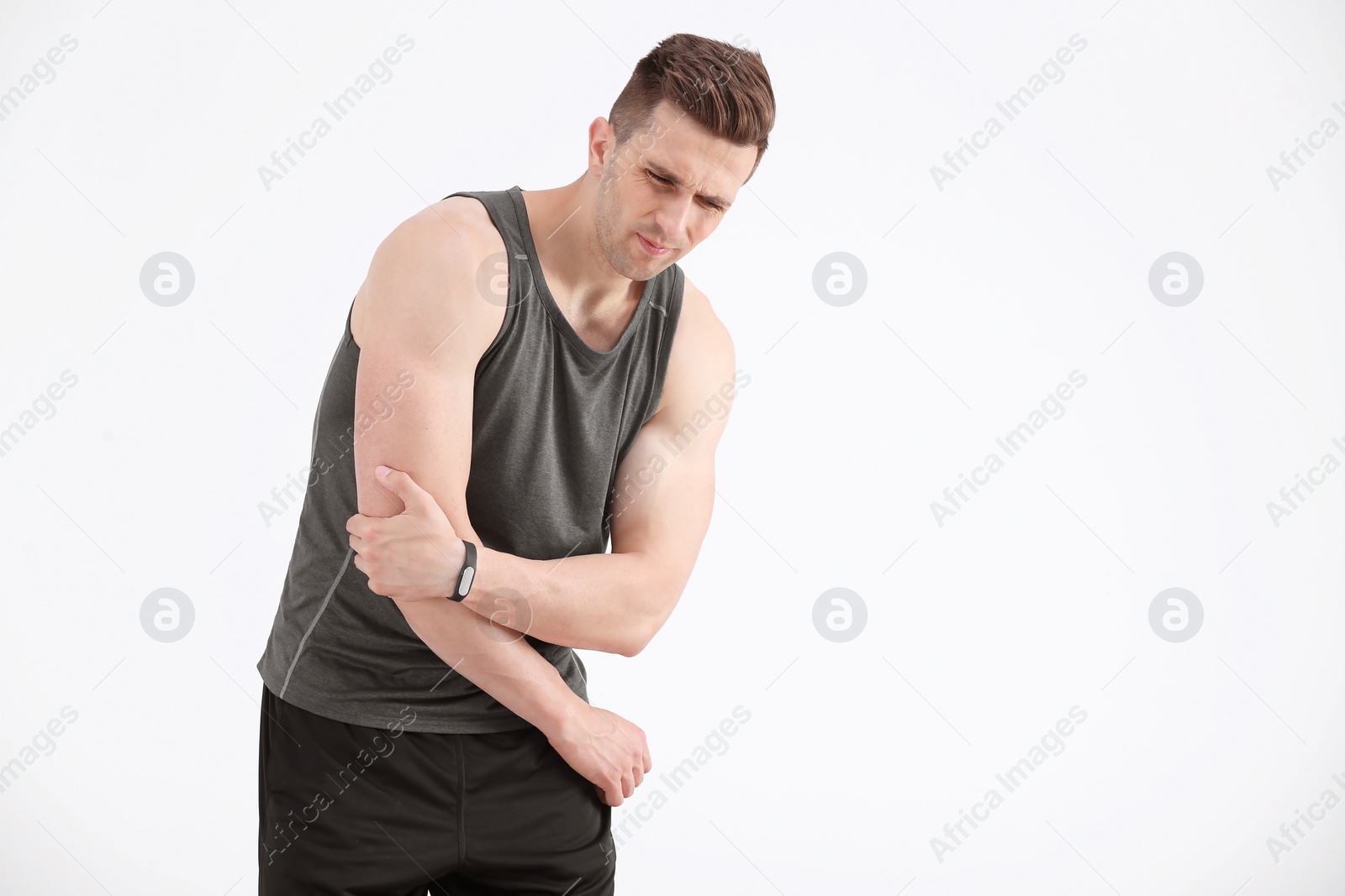 Photo of Man in sportswear suffering from elbow pain on white background