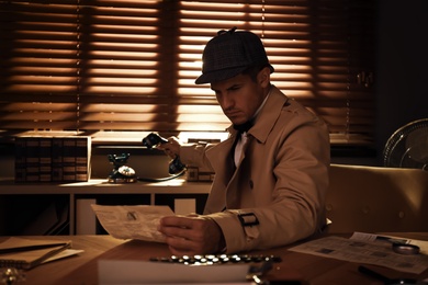 Photo of Old fashioned detective working at table in office