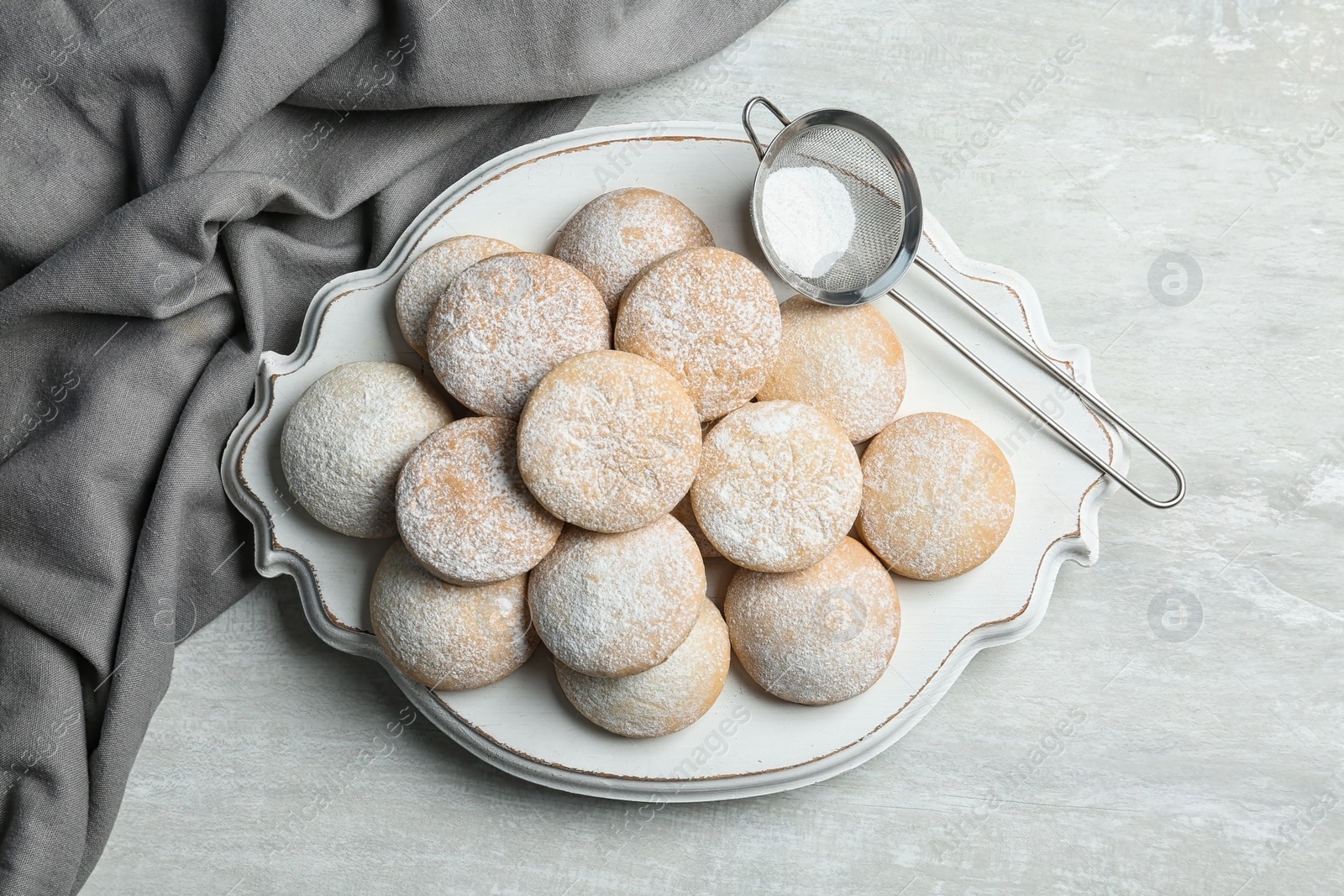 Photo of Traditional cookies for Islamic holidays and strainer with powdered sugar on table, top view. Eid Mubarak