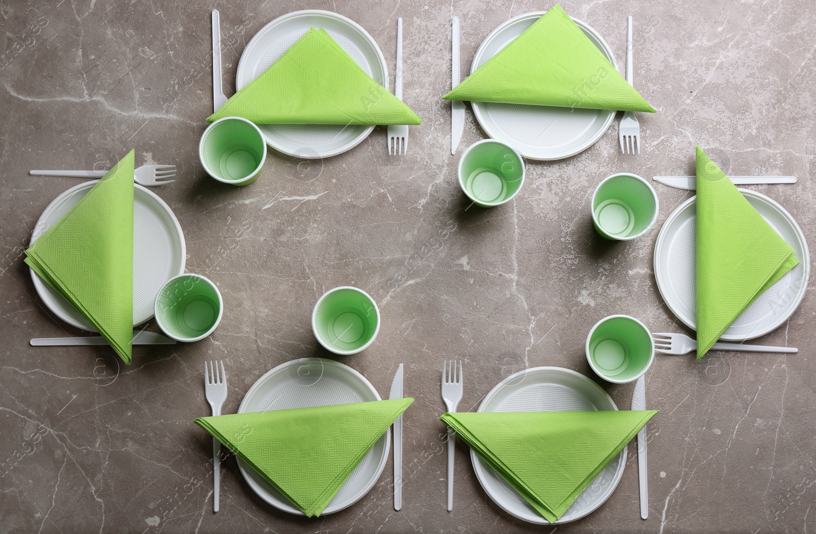 Photo of Composition with plastic dishware on grey background, flat lay. Picnic table setting