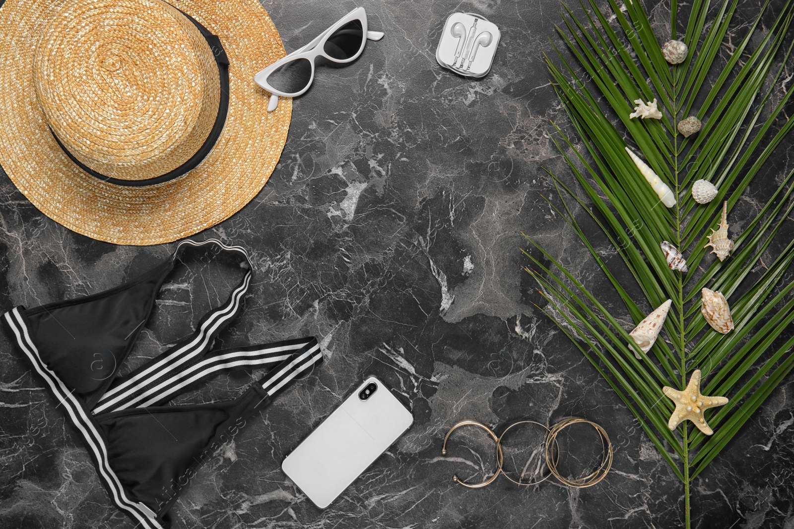 Photo of Flat lay composition with smartphone and beach objects on dark background