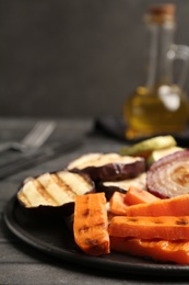 Photo of Delicious grilled vegetables served on grey table, closeup