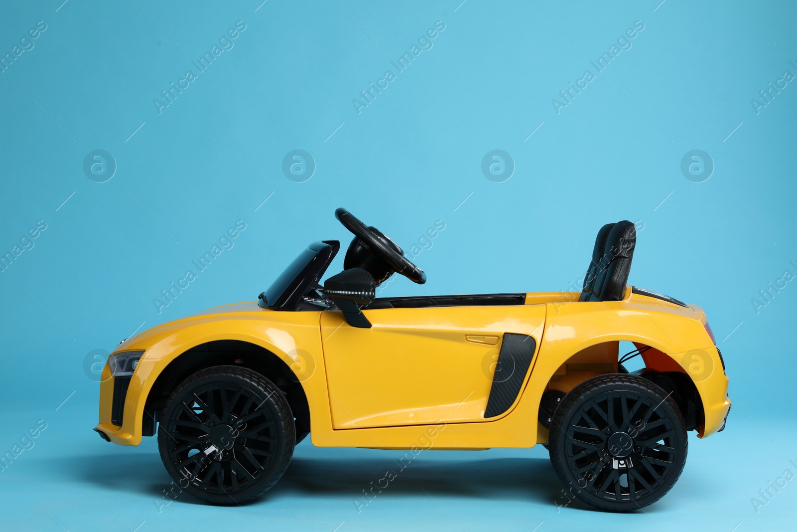 Photo of Child's electric toy car on light blue background