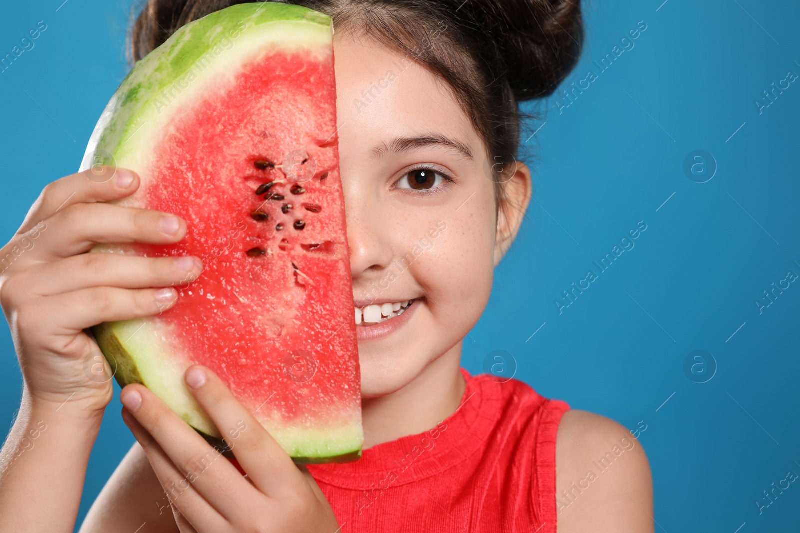 Photo of Cute little girl with watermelon on blue background, closeup