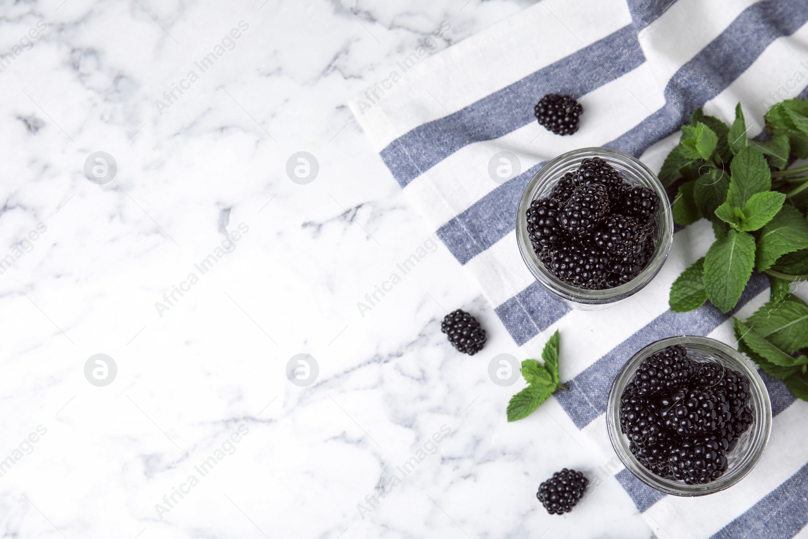Photo of Flat lay composition with tasty blackberries and space for text on marble table