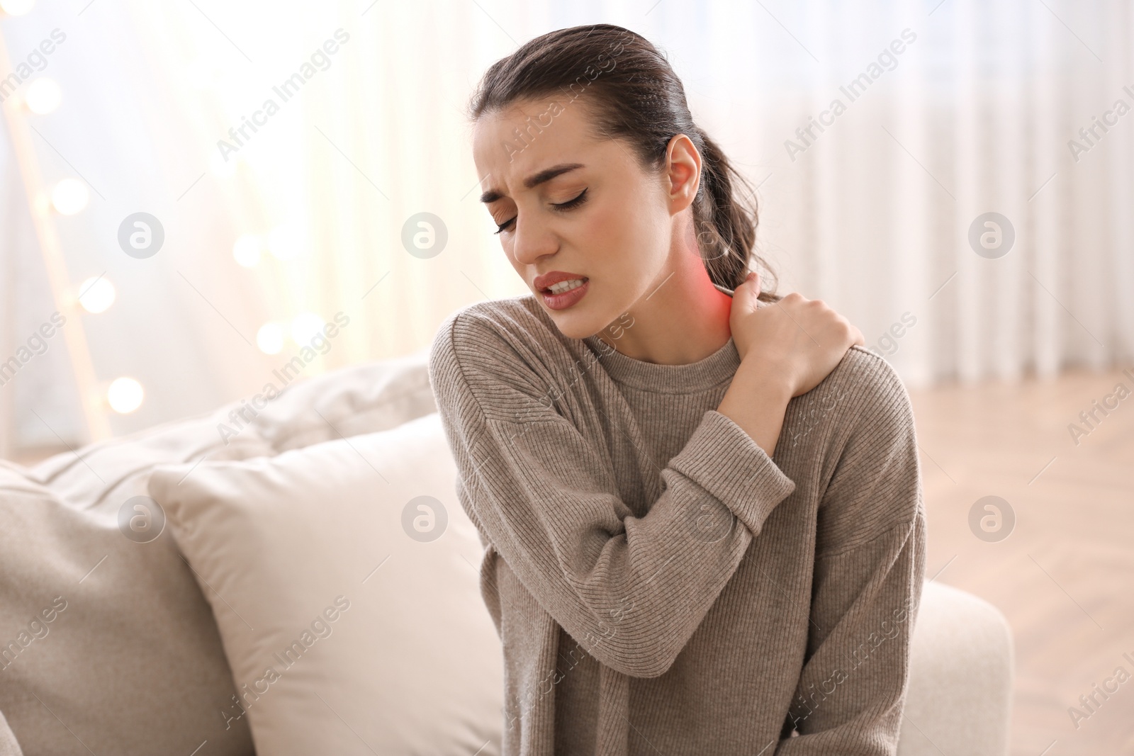 Image of Woman suffering from neck pain at home