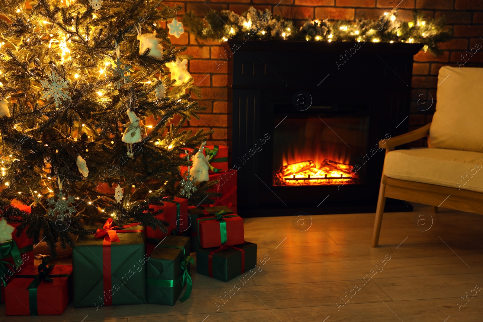 Photo of Beautifully wrapped gift boxes under Christmas tree in living room