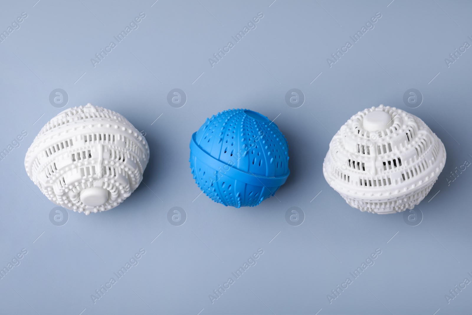 Photo of Dryer balls for washing machine on light grey background, flat lay