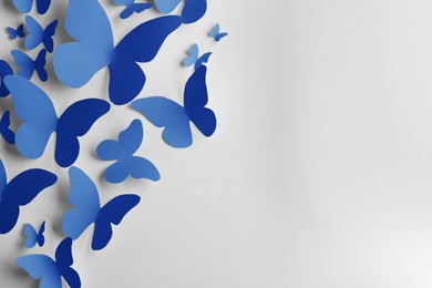 Image of Bright blue paper butterflies on white wall