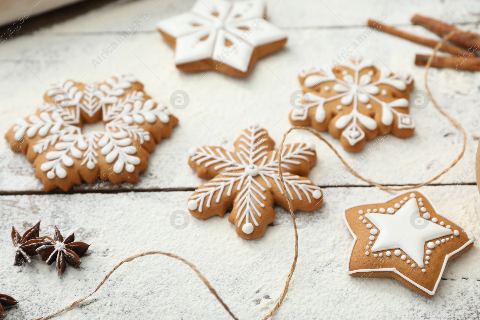 Photo of Delicious homemade Christmas cookies and flour on wooden table, closeup