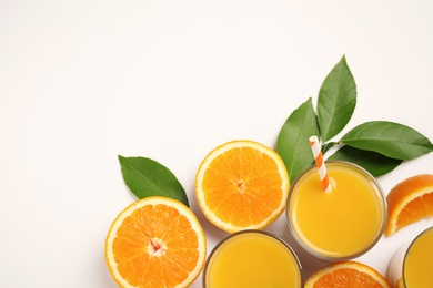 Glasses of orange juice and fresh fruits on white background, top view