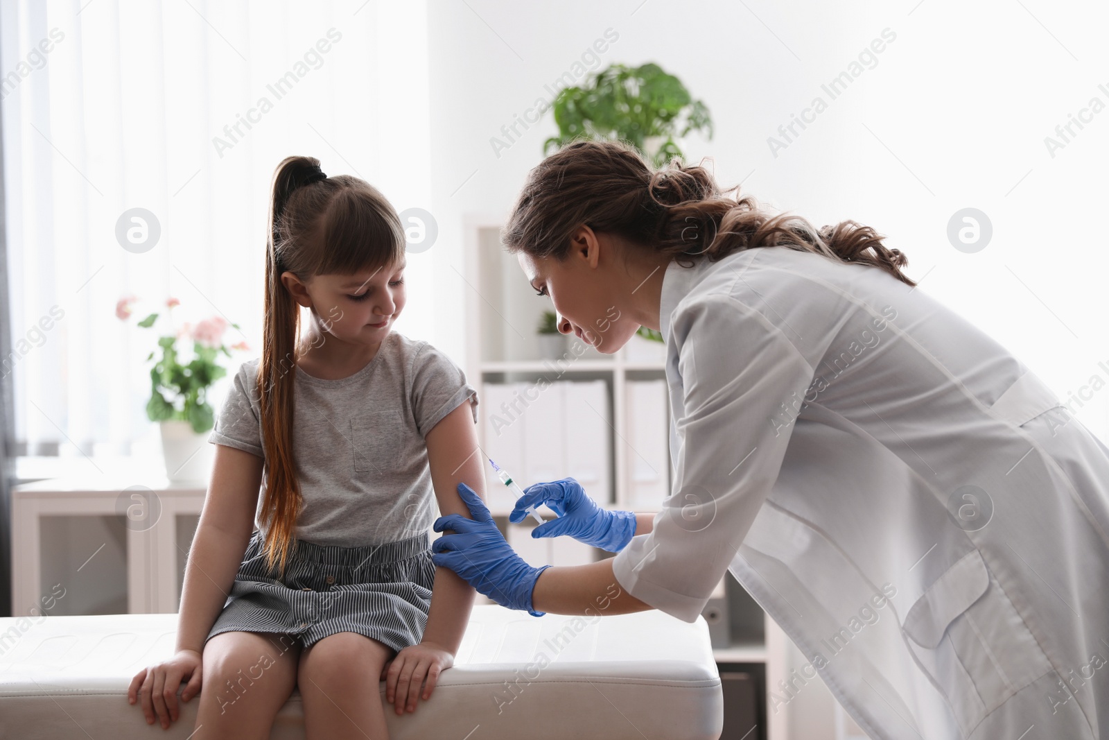 Photo of Little girl receiving chickenpox vaccination in clinic. Varicella virus prevention