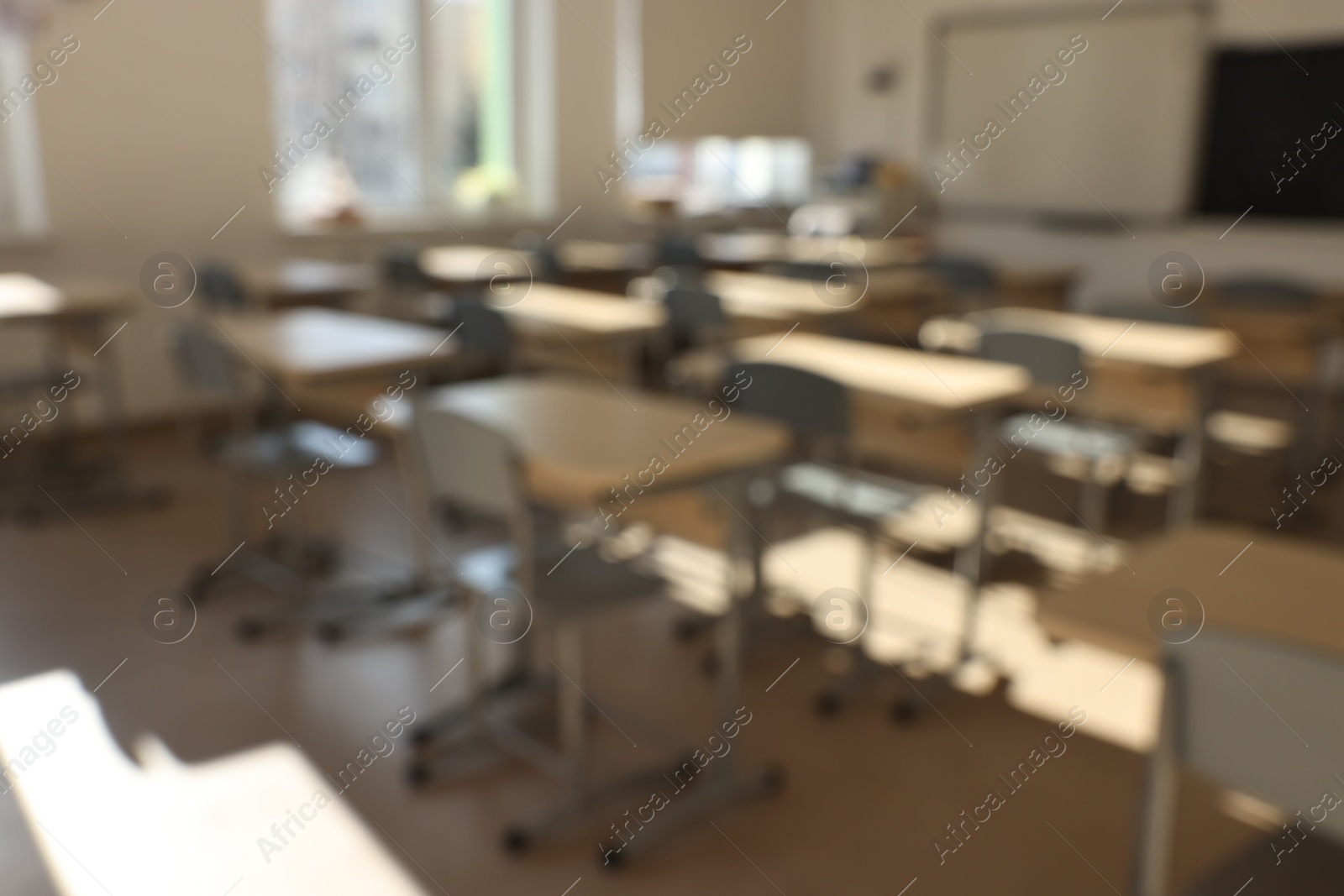 Photo of Blurred view of empty school classroom with desks and chairs