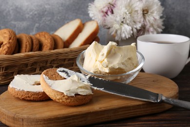 Photo of Tasty homemade butter, cookies and cup of tea on wooden table, closeup