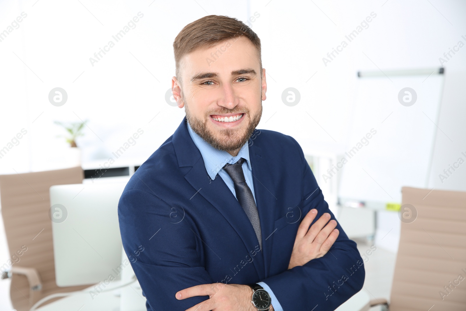 Photo of Portrait of young businessman laughing at workplace