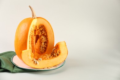 Photo of Cut fresh ripe pumpkin on white background, space for text