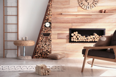 Photo of Decorative fireplace with stacked wood in cozy living room interior