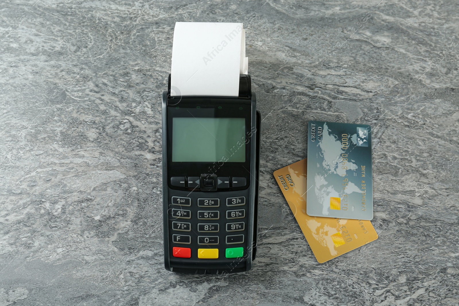 Photo of New modern payment terminal and credit cards on grey table, flat lay