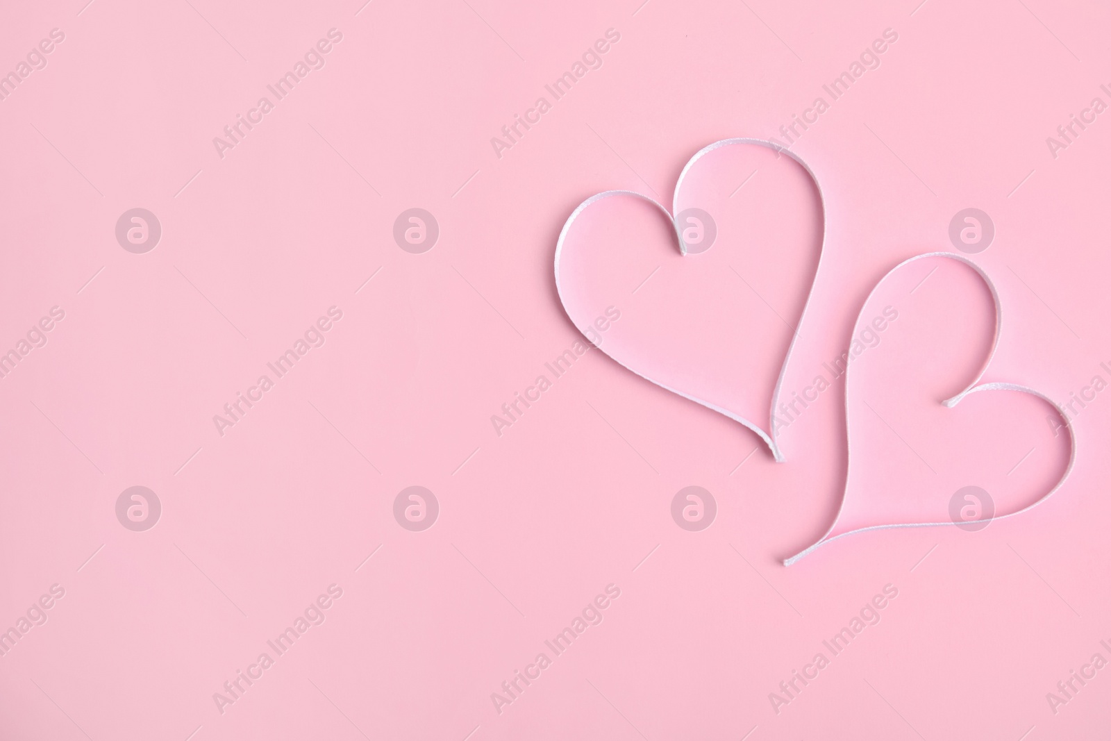 Photo of Hearts made of white ribbon on pink background, flat lay with space for text. Valentine's day celebration