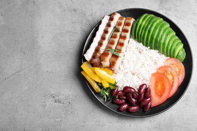 Photo of Delicious rice with beans and meat on grey table, top view. Space for text