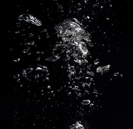 Many air bubbles in water on black background