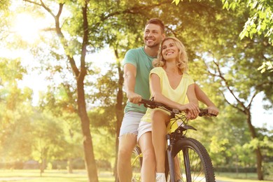 Image of Lovely couple with bicycle in park on sunny day