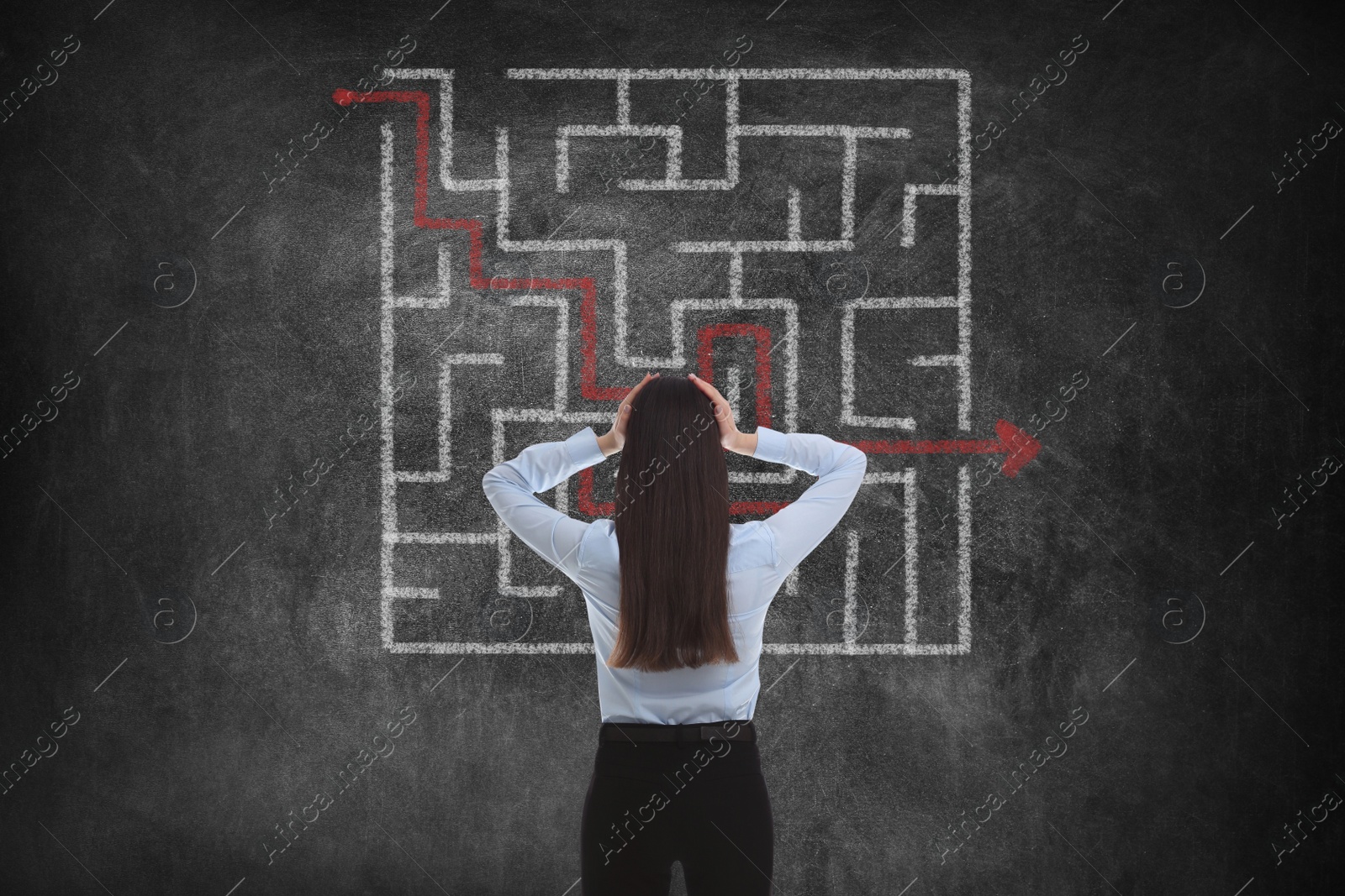 Image of Businesswoman looking at chalkboard with illustration of maze