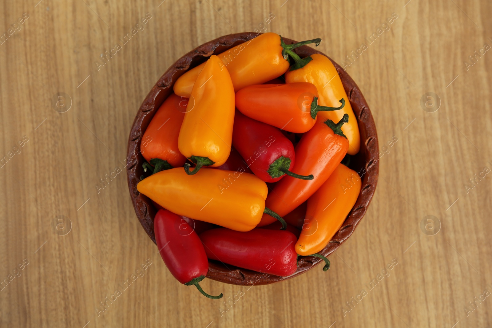 Photo of Ripe bell peppers on wooden table, top view