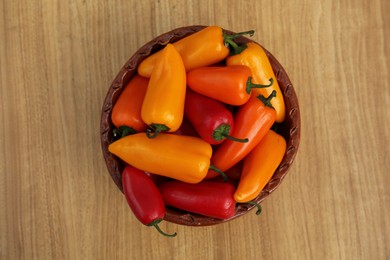 Photo of Ripe bell peppers on wooden table, top view