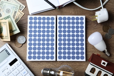Photo of Flat lay composition with solar panels and money on wooden table