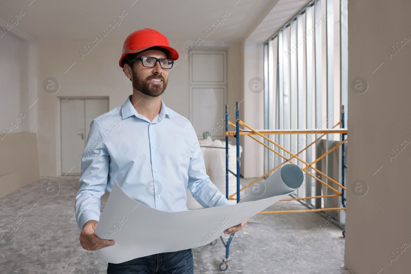 Photo of Professional engineer in hard hat with draft indoors