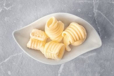 Photo of Plate with fresh butter curls on table, top view