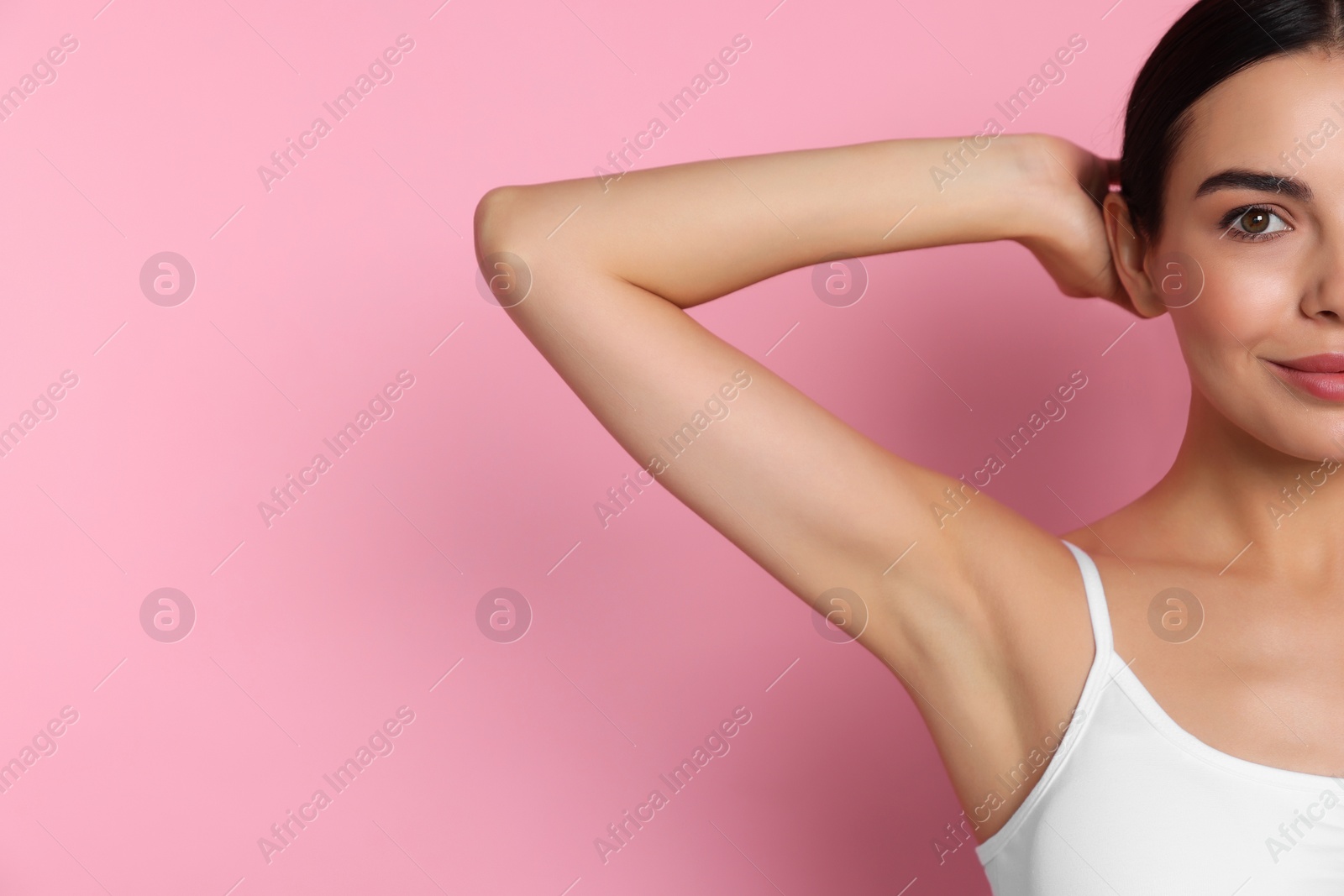 Photo of Young woman showing smooth skin after epilation on pink background, closeup. Space for text