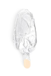 Photo of Ice cream bar wrapped in foil on white background, top view