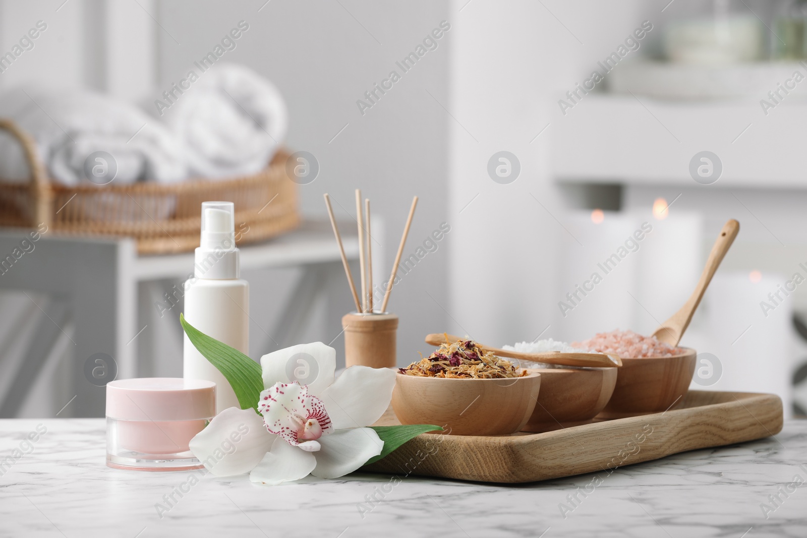 Photo of Beautiful composition with different spa products and orchid flower on white marble table indoors