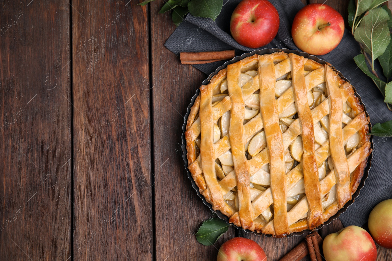 Photo of Delicious traditional apple pie on wooden table, flat lay. Space for text