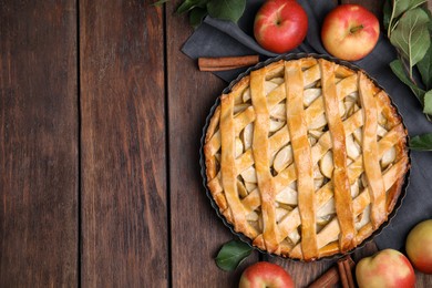 Delicious traditional apple pie on wooden table, flat lay. Space for text