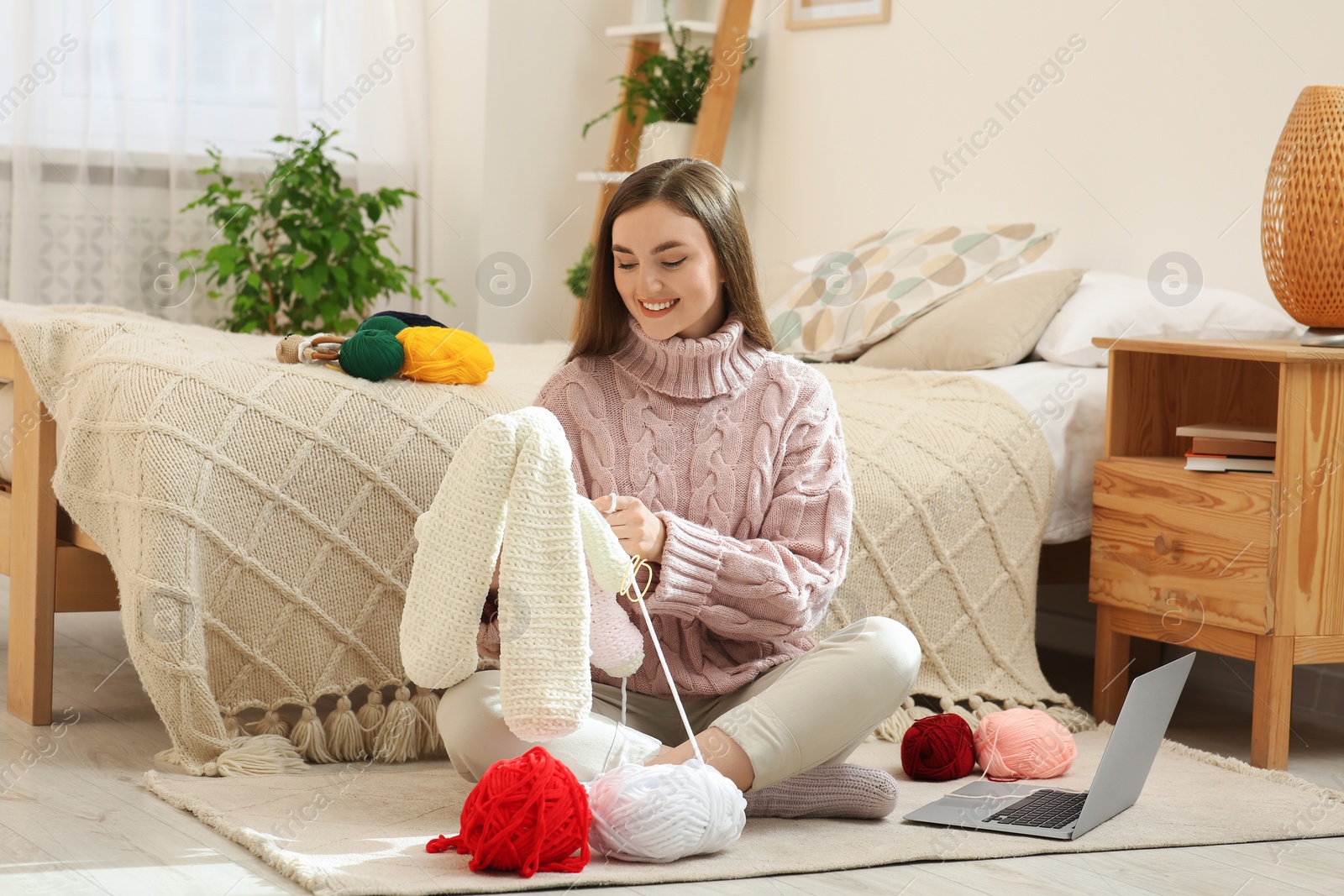 Photo of Woman learning to knit with online course at home. Handicraft hobby