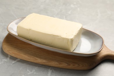 Block of tasty butter on grey table