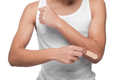 Man putting sticking plaster onto elbow on white background, closeup