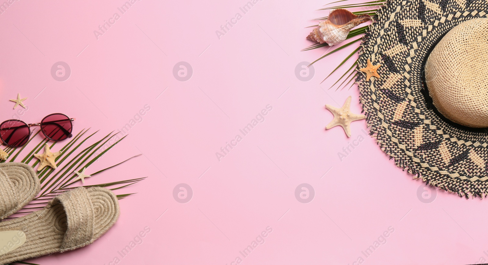 Photo of Beach accessories on pink background, flat lay. Space for text