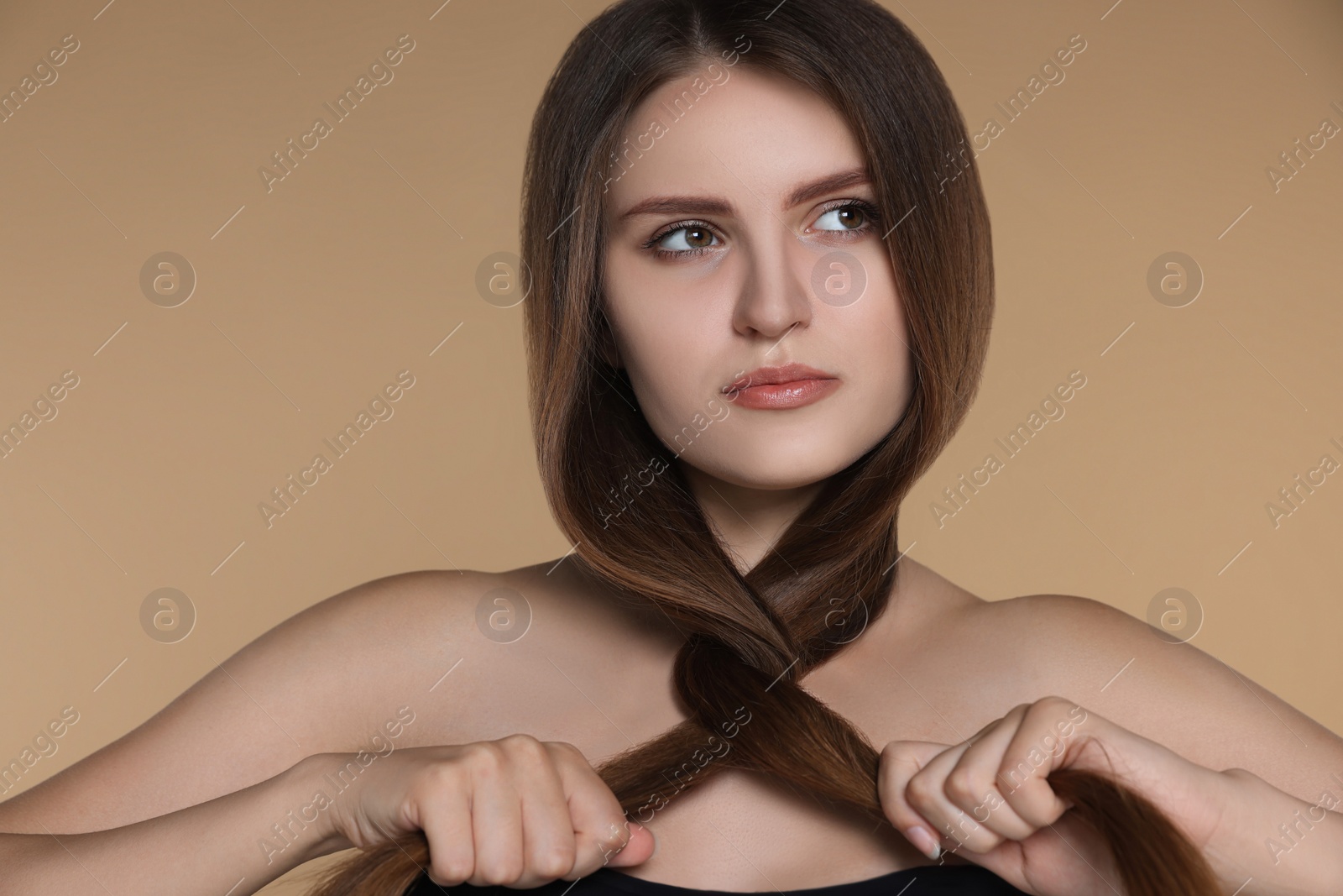 Photo of Young woman with strong healthy hair on beige background