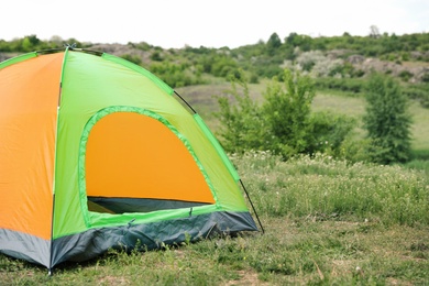 Photo of Small tourist tent in wilderness. Camping season