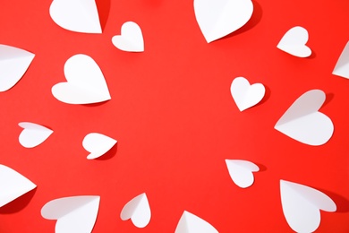 Small paper hearts on color background, top view