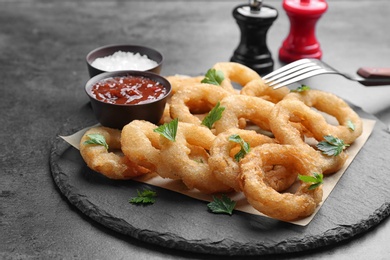 Fried onion rings served with sauces on slate plate